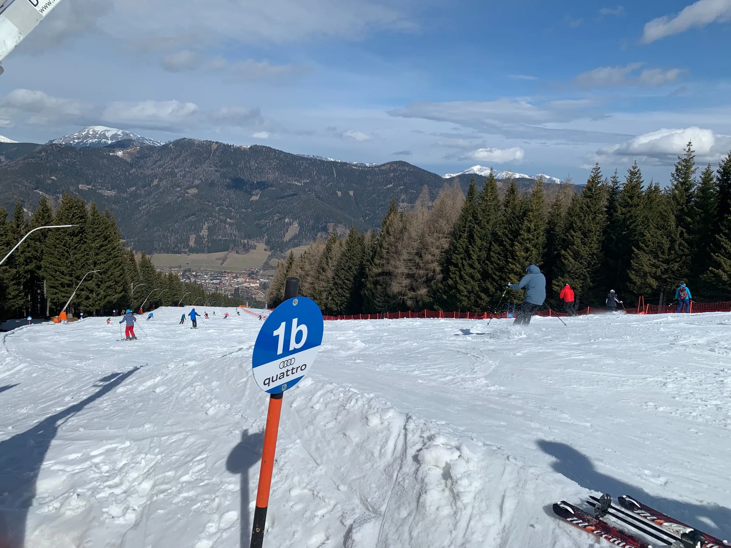 Skipiste am Stuhleck mit Skifahrenden, Pistenmarkierung 1b und Bergblick