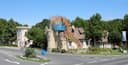 Geschwungener Eingangsbereich des Familyparks mit Logo, Maskottchen und steinernen Türmen