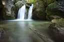 Wasserfall und grünliches Wasserbecken zwischen Felsen bei den Myrafällen