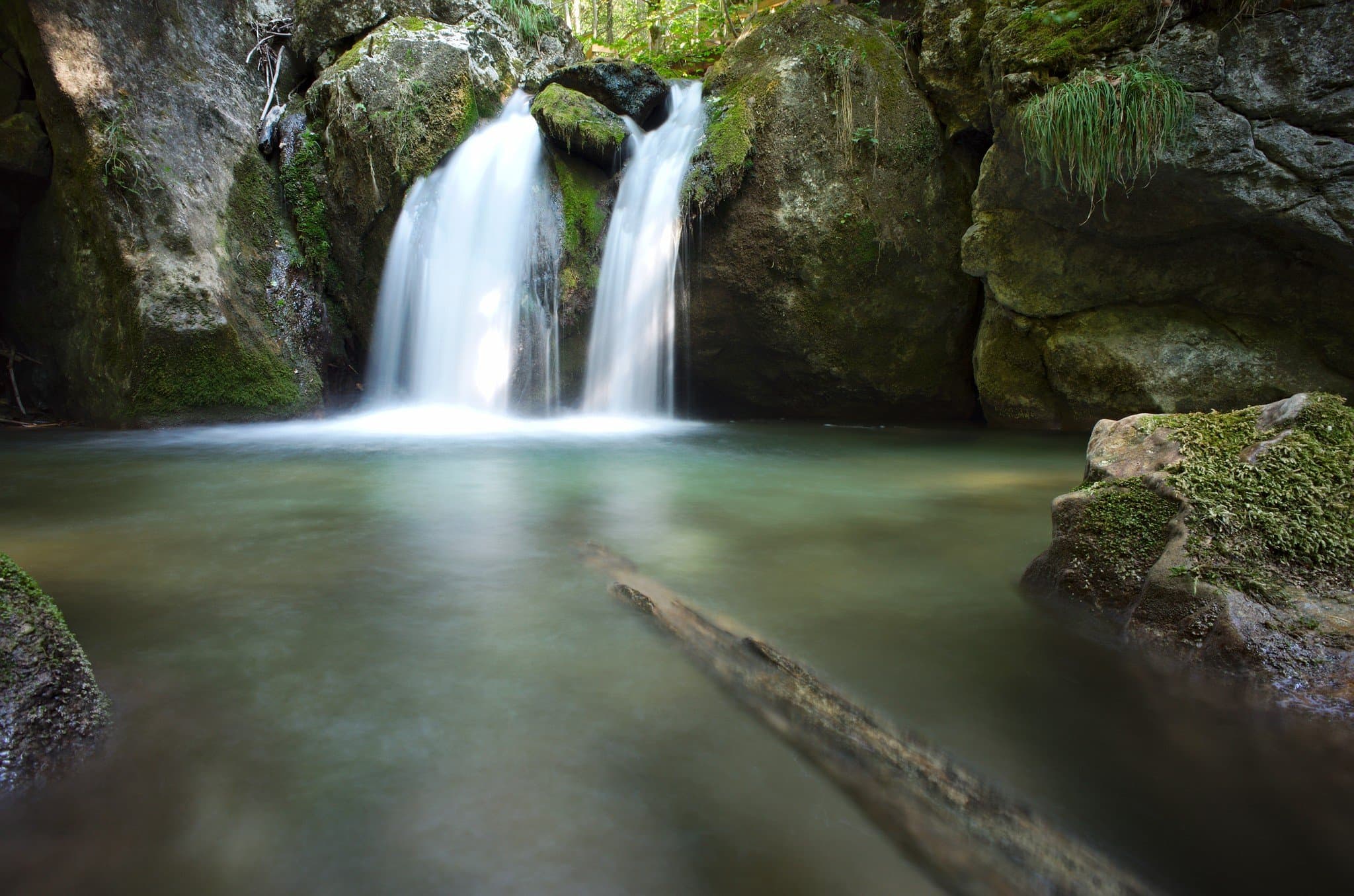 Wasserfall und grünliches Wasserbecken zwischen Felsen bei den Myrafällen