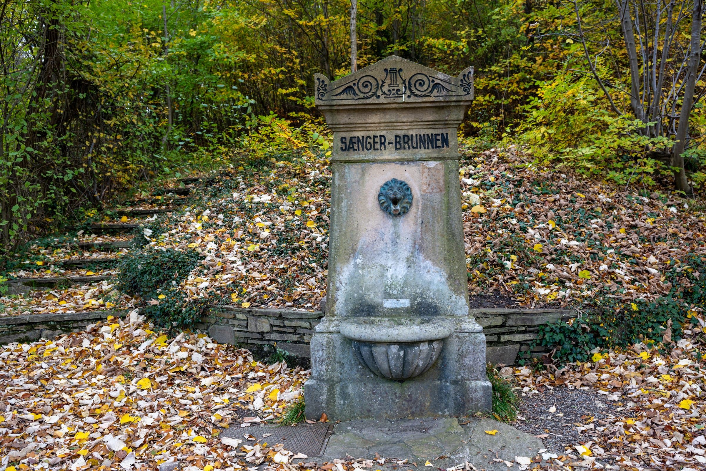 Sängerbrunnen zwischen herbstlichen Bäumen im Naturpark Purkersdorf
