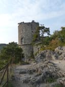 Schwarzer Turm auf einem Felsvorsprung mit Geländer und Treppenweg bei Mödling