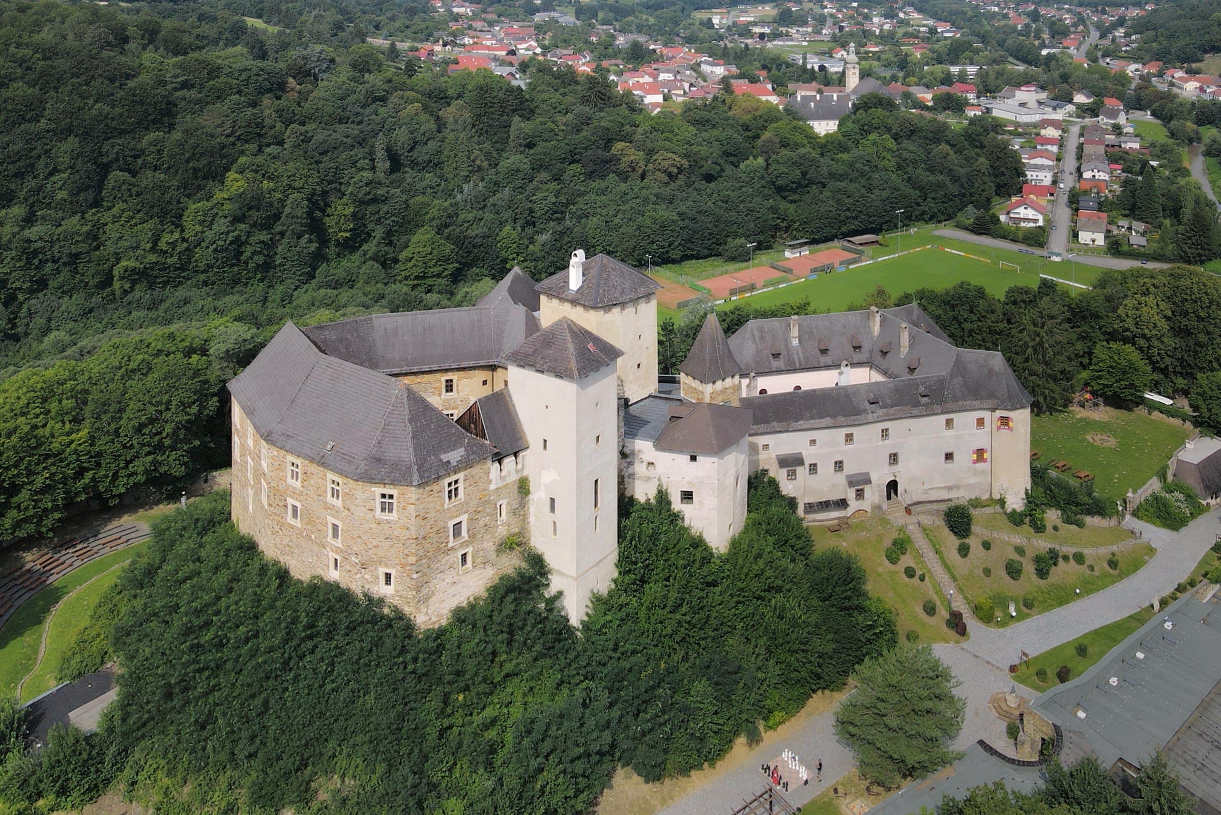 Luftaufnahme der Burg Lockenhaus auf einem bewaldeten Hügel