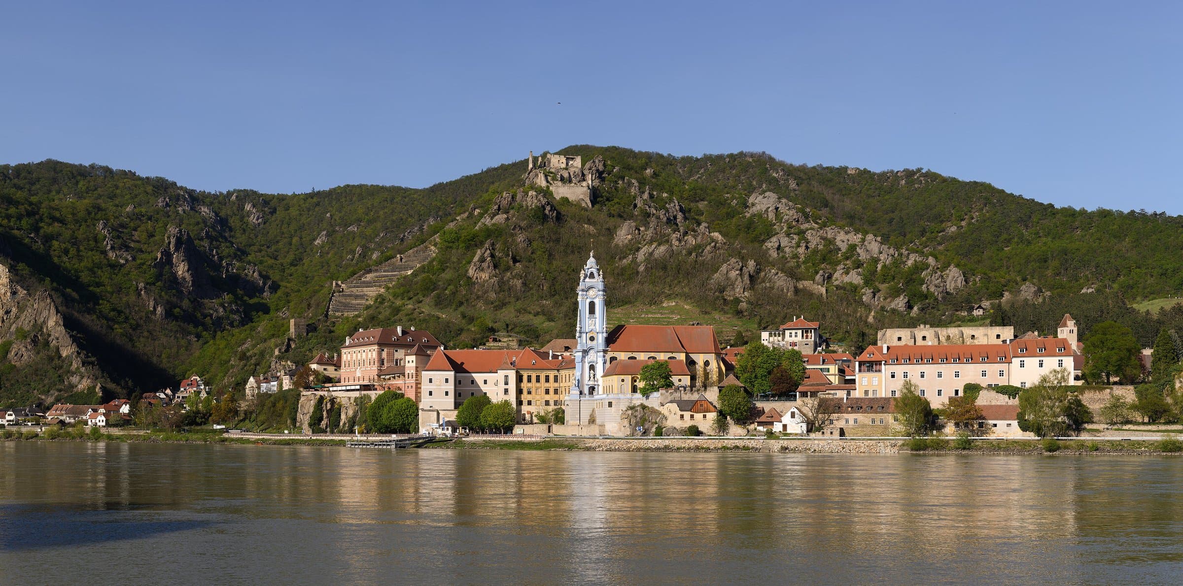 Dürnstein am Donauufer mit blauem Kirchturm und Burgruine auf dem felsigen Hügel