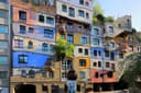 Farbige Fassadenflächen, Säulen und begrünte Balkone am Hundertwasserhaus
