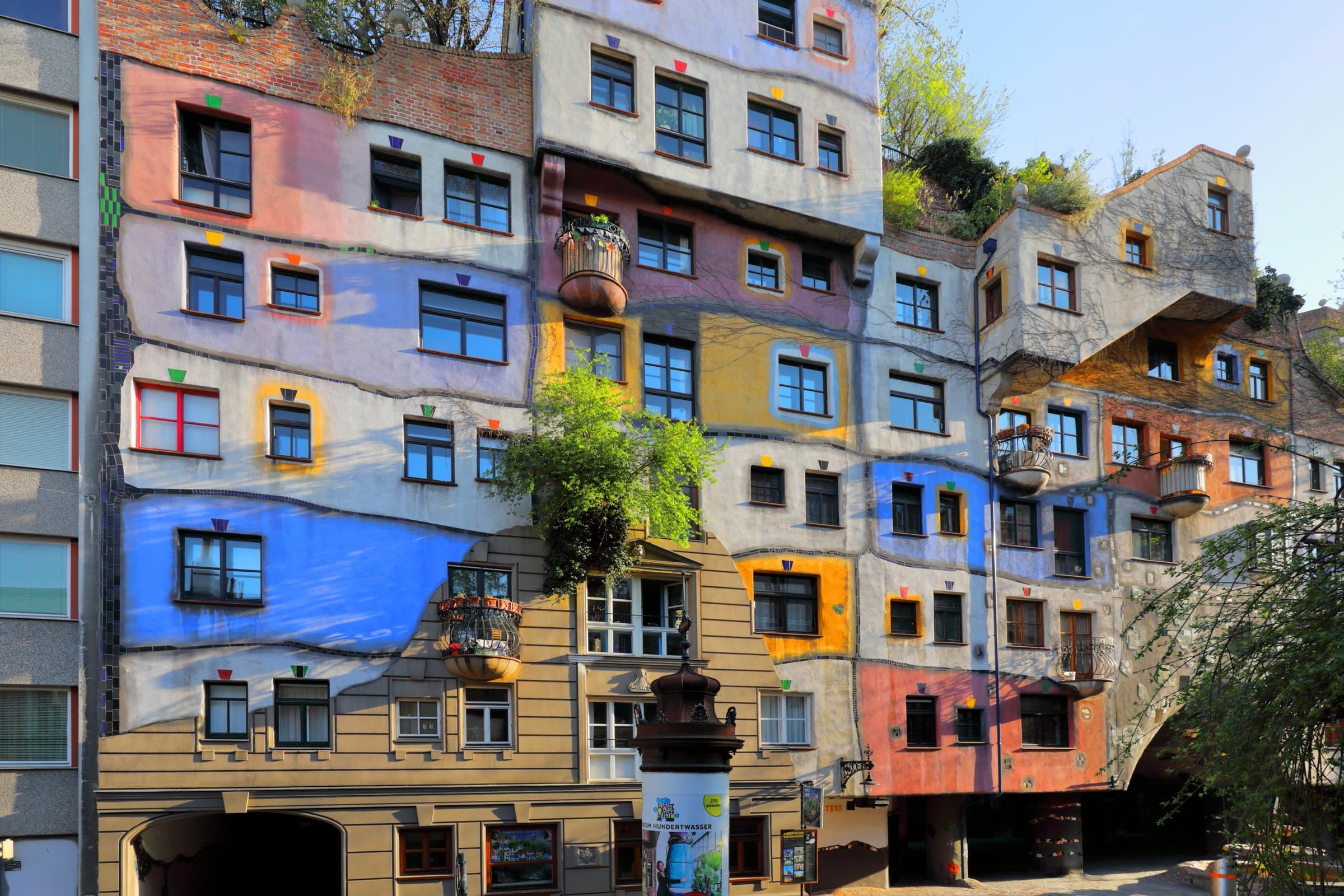 Farbige Fassadenflächen, Säulen und begrünte Balkone am Hundertwasserhaus