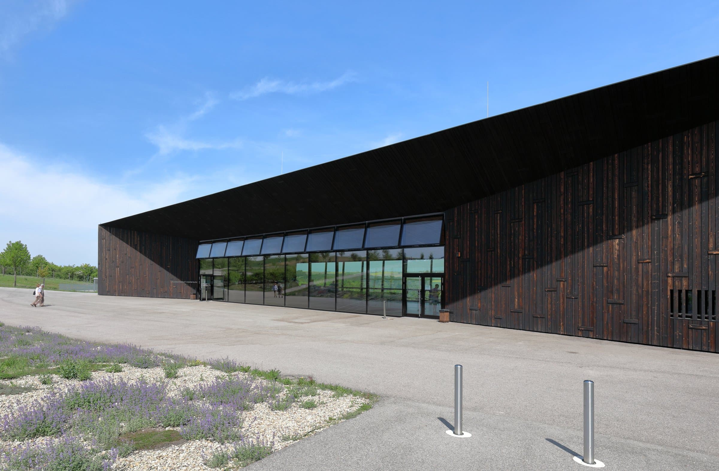 Dunkles Besucherzentrum mit breiter Glasfront im Museumsdorf Niedersulz