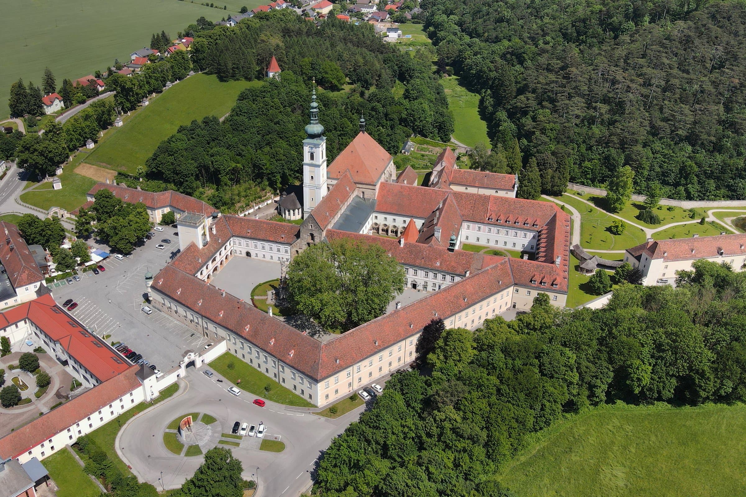 Luftaufnahme von Stift Heiligenkreuz mit Kirche, Innenhöfen und roten Ziegeldächern